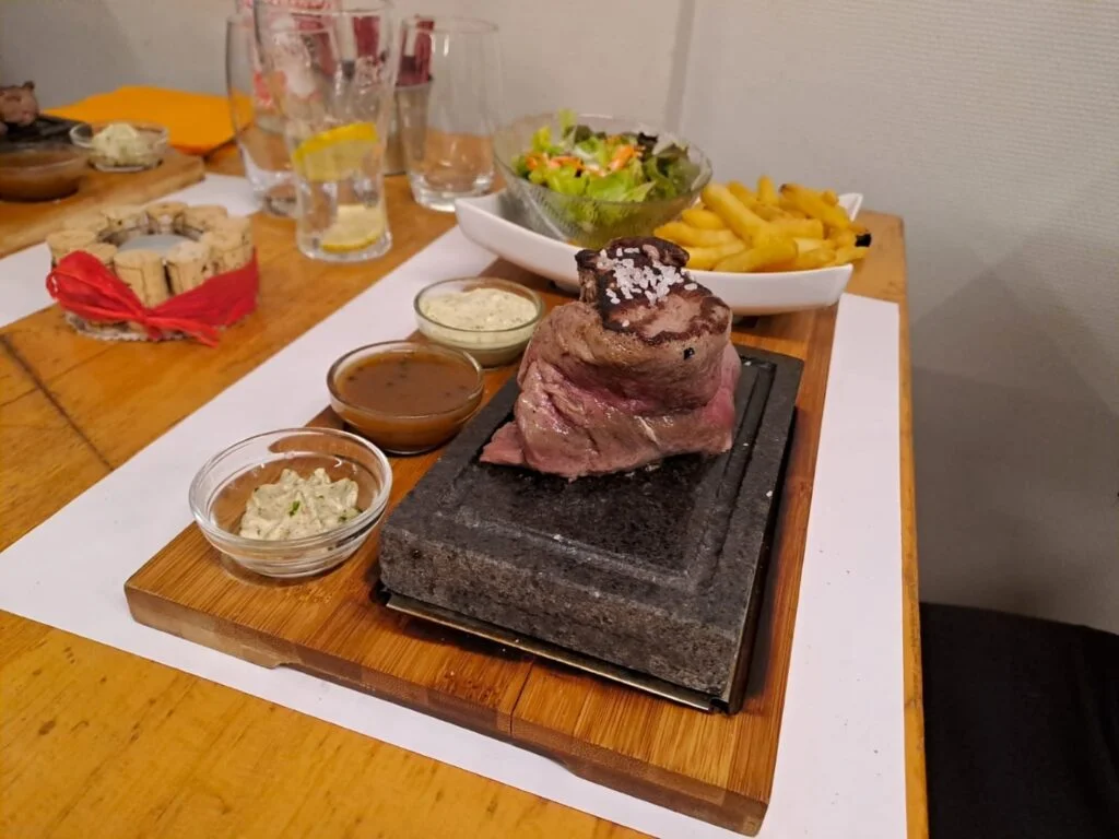 une table d'un restaurant alsacien avec de la viande sur pierre